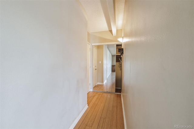 hallway featuring baseboards and light wood-type flooring