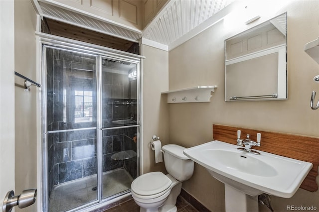 full bathroom featuring a stall shower, toilet, and a sink