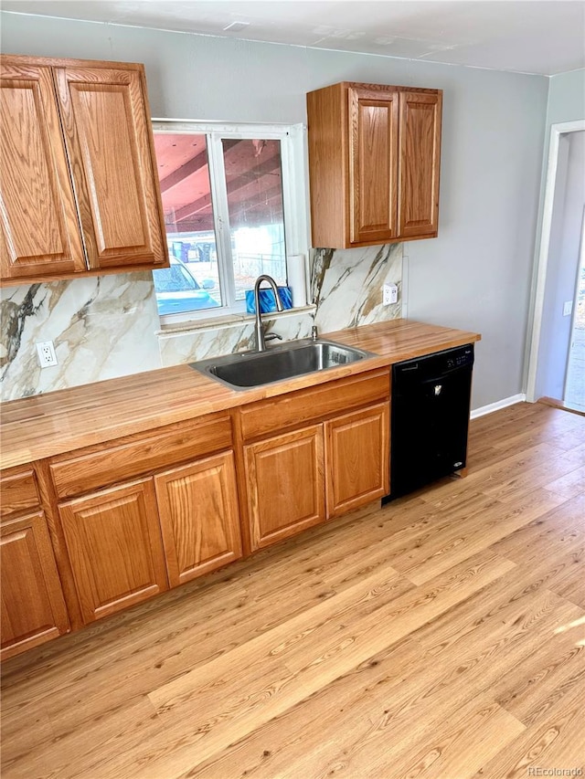 kitchen with black dishwasher, tasteful backsplash, light hardwood / wood-style floors, and sink