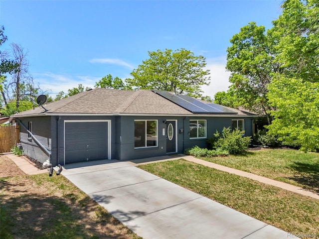 971 Ursula St, Aurora, CO 80011 - single story home featuring an attached garage, a shingled roof, roof mounted solar panels, and concrete driveway