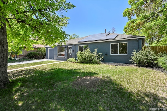 971 Ursula St, Aurora, CO 80011 - ranch-style home with an attached garage, roof mounted solar panels, concrete driveway, and brick siding