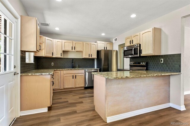 971 Ursula St, Aurora, CO 80011 - kitchen featuring stainless steel appliances, light brown cabinets, a peninsula, a sink, and recessed lighting