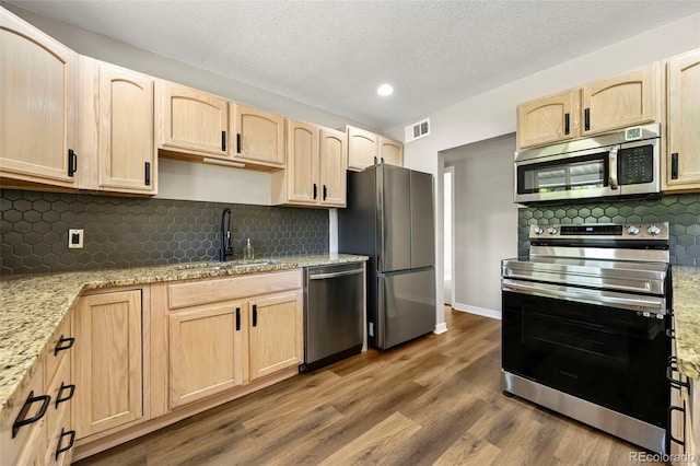971 Ursula St, Aurora, CO 80011 - kitchen featuring stainless steel appliances, light brown cabinetry, a sink, recessed lighting, and a textured ceiling