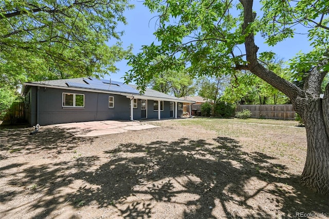 971 Ursula St, Aurora, CO 80011 - rear view of house with a patio, a fenced backyard, and solar panels