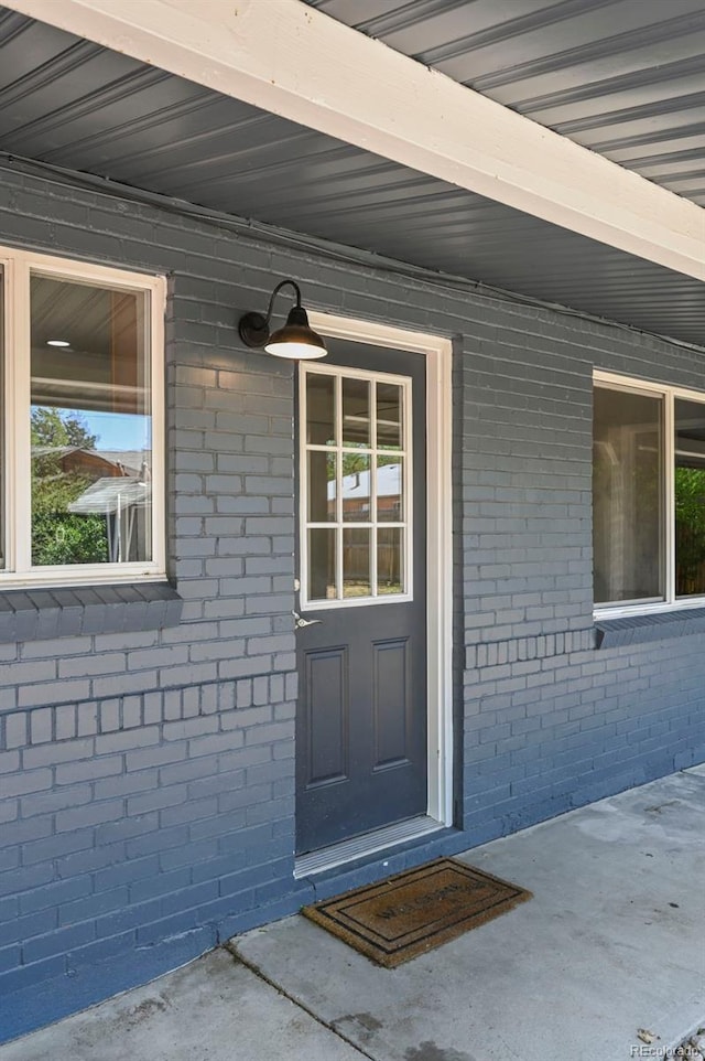 971 Ursula St, Aurora, CO 80011 - doorway to property with brick siding and a porch