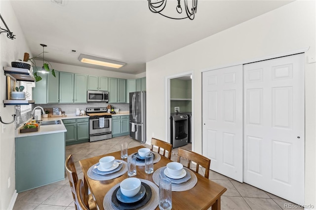 9630 Yukon Way, Colorado Springs, CO 80925 - dining space featuring light tile patterned floors, washer / clothes dryer, and a chandelier