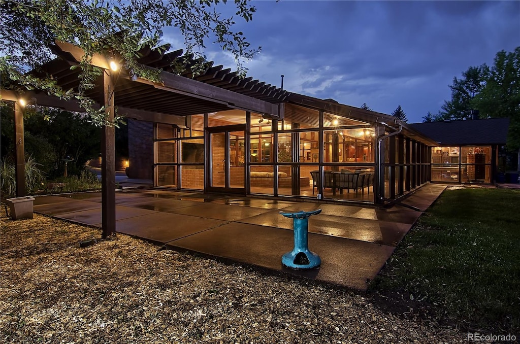 back house at dusk with a patio area