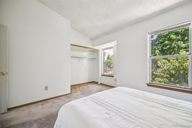 4220 Hunting Meadows Cir, Colorado Springs, CO 80916 - carpeted bedroom with a textured ceiling, multiple windows, vaulted ceiling, and a closet