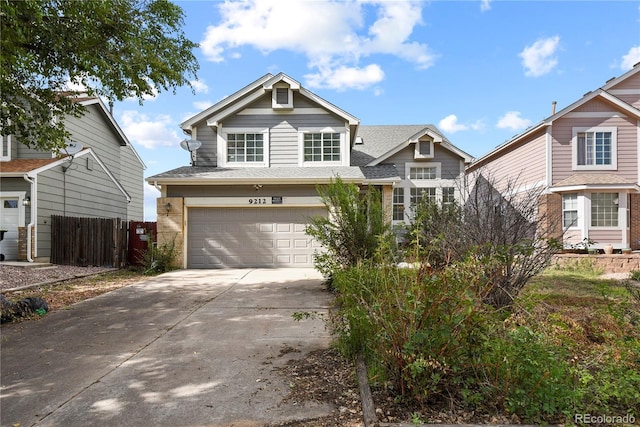 view of front of home with an attached garage, fence, and concrete driveway