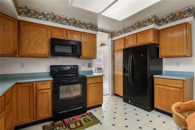 kitchen featuring black appliances, brown cabinetry, and light countertops