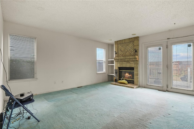 unfurnished living room featuring a textured ceiling, carpet floors, and a fireplace