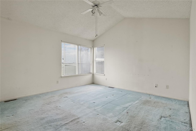 spare room with visible vents, light colored carpet, lofted ceiling, ceiling fan, and a textured ceiling