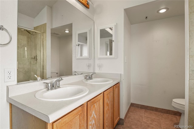 bathroom featuring a stall shower, a sink, toilet, and tile patterned floors