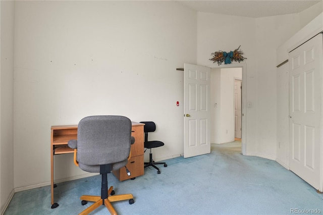 office area featuring light carpet and baseboards