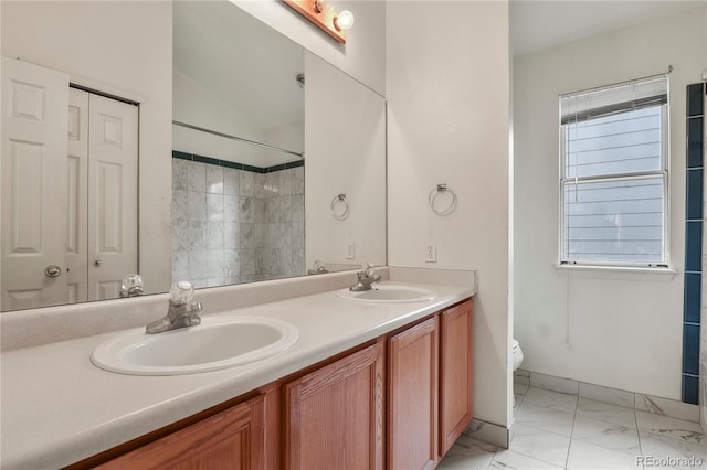 bathroom featuring marble finish floor, a closet, and a sink