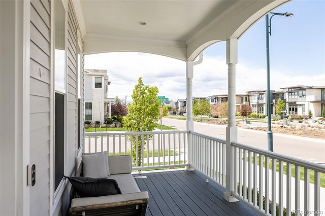 wooden deck with a residential view and covered porch