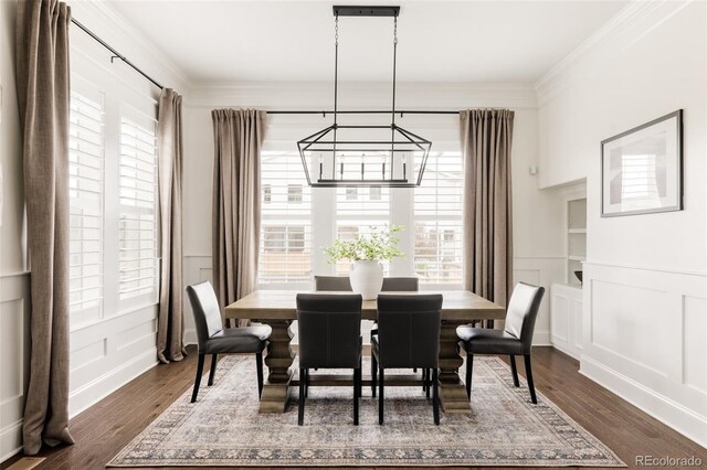 dining space with dark wood-style flooring, an inviting chandelier, and a decorative wall