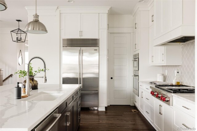 kitchen with custom range hood, a sink, dark wood-style floors, stainless steel appliances, and white cabinetry