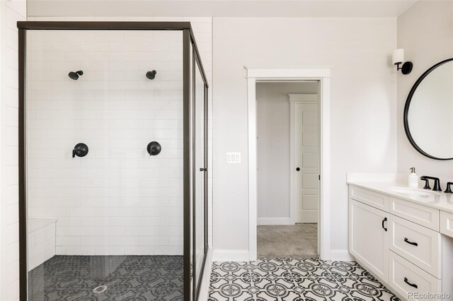 full bath with baseboards, a shower stall, tile patterned floors, and vanity
