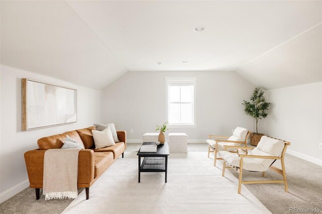 living room featuring light colored carpet, baseboards, and vaulted ceiling