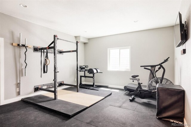 exercise area featuring baseboards and recessed lighting