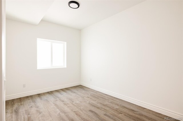 empty room featuring baseboards and wood finished floors