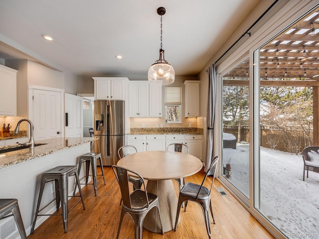 dining room with sink and light wood-type flooring