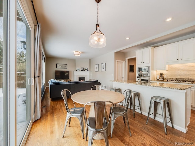 dining space with sink and light wood-type flooring