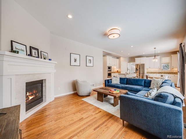 living room featuring sink and light wood-type flooring