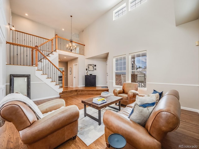 living room featuring a towering ceiling, wood-type flooring, and a wealth of natural light