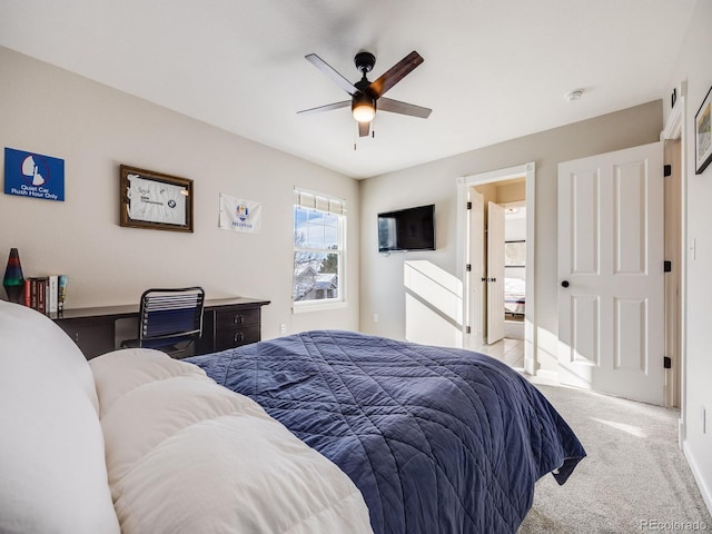 carpeted bedroom featuring built in desk and ceiling fan