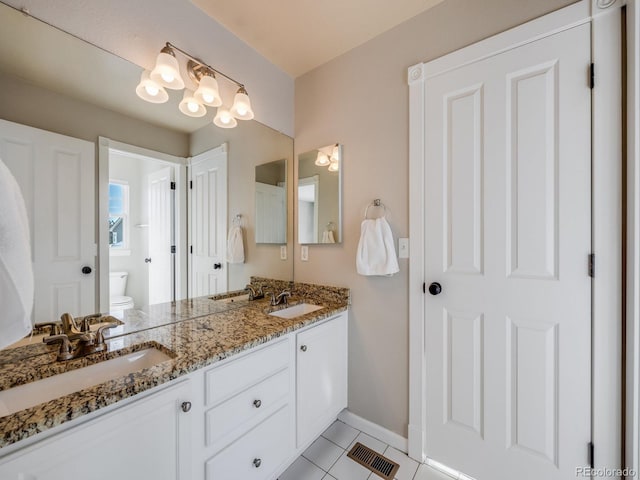 bathroom featuring vanity, tile patterned floors, and toilet