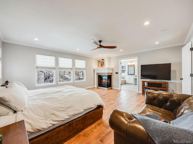 bedroom with crown molding, ceiling fan, ensuite bathroom, and light wood-type flooring