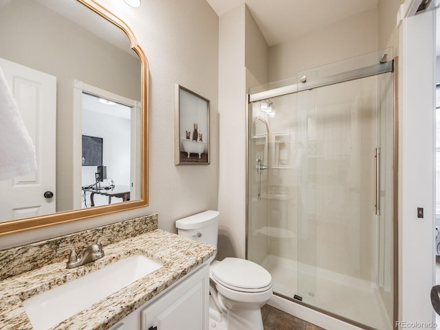 bathroom featuring vanity, a shower with door, and toilet