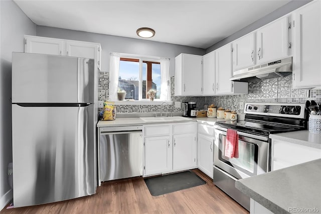 kitchen with backsplash, white cabinetry, sink, and stainless steel appliances