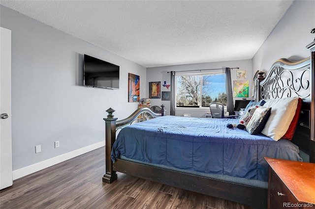 bedroom featuring dark hardwood / wood-style flooring and a textured ceiling