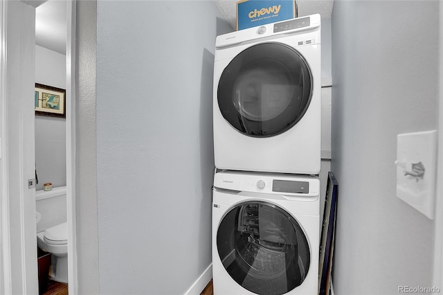 washroom featuring stacked washing maching and dryer