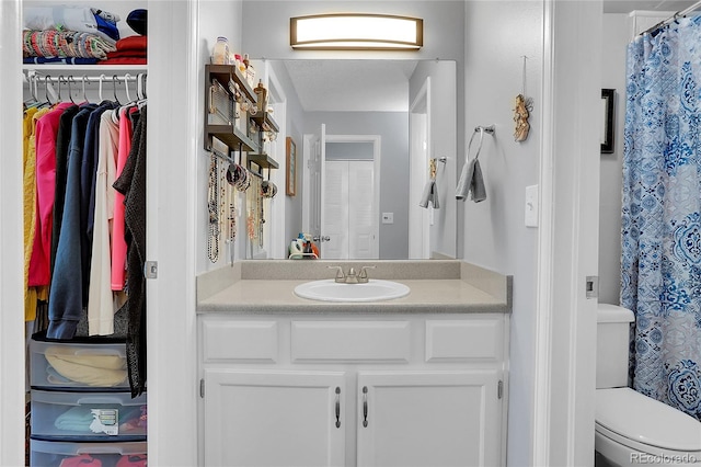 bathroom with a shower with curtain, vanity, and toilet