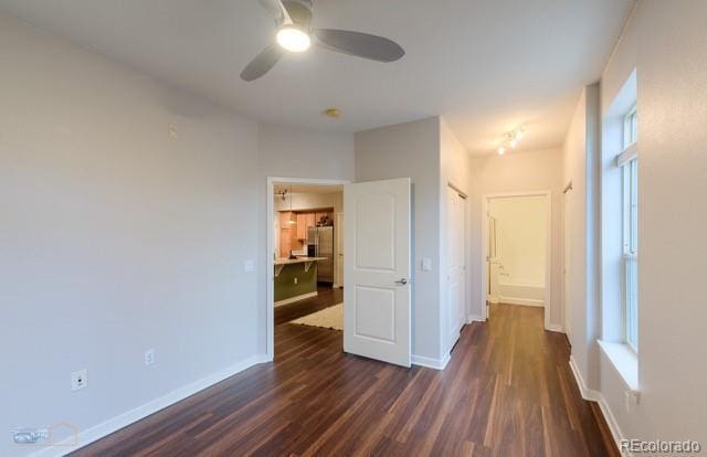 13456 Via Varra Unit 114, Broomfield, CO 80020 - unfurnished room featuring baseboards, a ceiling fan, dark wood-style flooring, and a healthy amount of sunlight