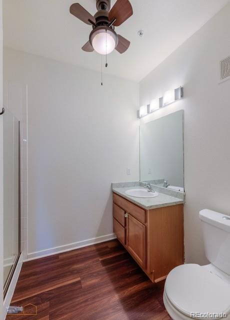 13456 Via Varra Unit 114, Broomfield, CO 80020 - bathroom with vanity, toilet, a ceiling fan, wood finished floors, and a shower with door