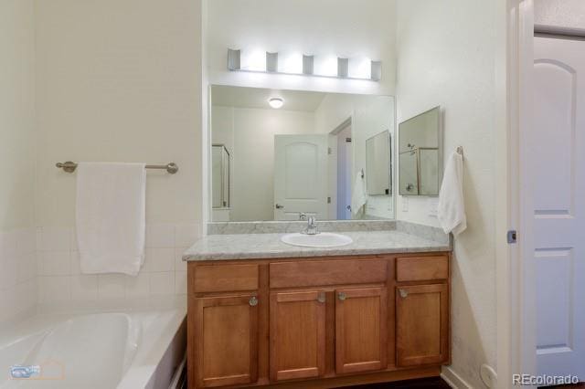 13456 Via Varra Unit 114, Broomfield, CO 80020 - bathroom featuring a garden tub and vanity