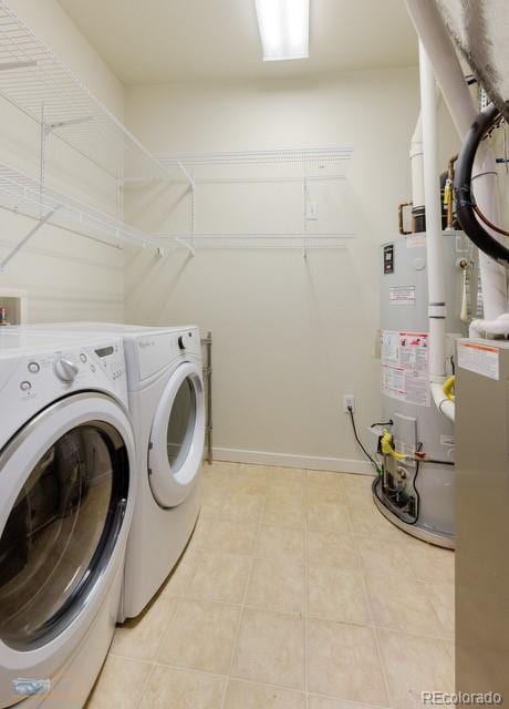 13456 Via Varra Unit 114, Broomfield, CO 80020 - laundry room with laundry area, washing machine and dryer, light tile patterned floors, baseboards, and water heater