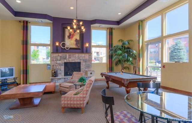13456 Via Varra Unit 114, Broomfield, CO 80020 - game room featuring a notable chandelier, a stone fireplace, billiards, and carpet