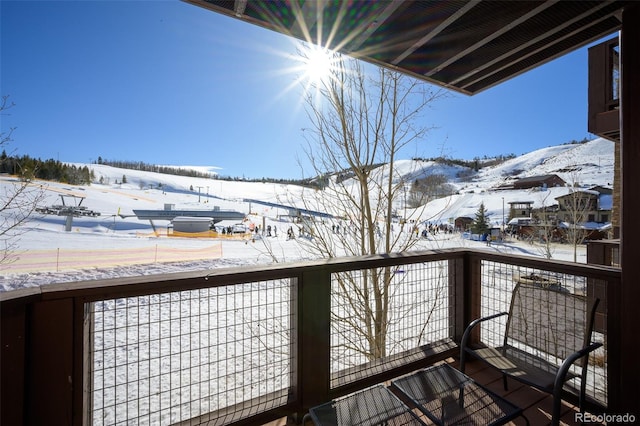 snow covered back of property featuring a mountain view