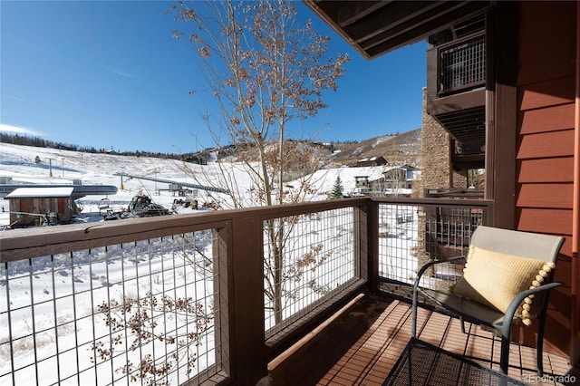 snow covered back of property featuring a mountain view