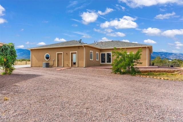 491 Newlin Ridge Rd, Florence, CO 81226 - rear view of house featuring a mountain view, fence, stucco siding, and gravel driveway