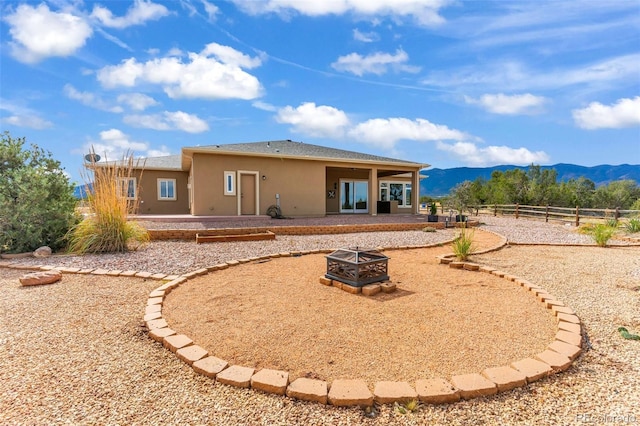 491 Newlin Ridge Rd, Florence, CO 81226 - back of house featuring an outdoor fire pit, a patio, stucco siding, and a mountain view