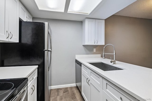 447 S Memphis Way Unit 7, Aurora, CO 80017 - kitchen featuring light wood-style floors, appliances with stainless steel finishes, white cabinetry, and light countertops