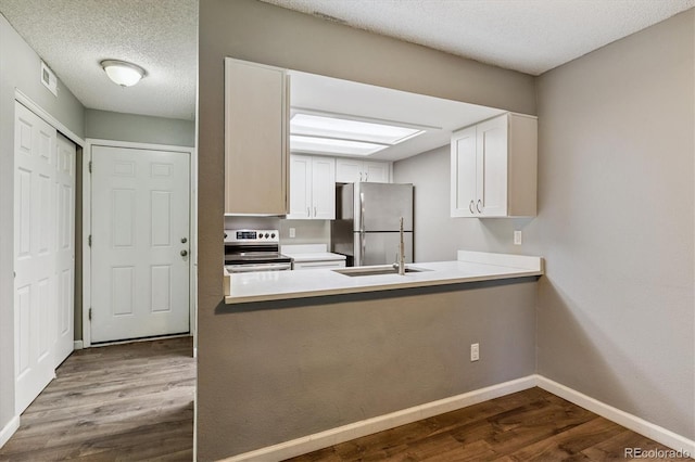 447 S Memphis Way Unit 7, Aurora, CO 80017 - kitchen featuring appliances with stainless steel finishes, dark wood-type flooring, white cabinetry, a peninsula, and light countertops