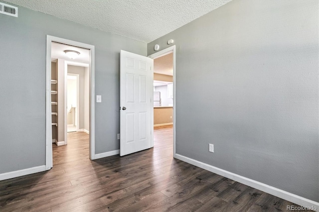 447 S Memphis Way Unit 7, Aurora, CO 80017 - unfurnished bedroom featuring dark wood-style floors and a textured ceiling